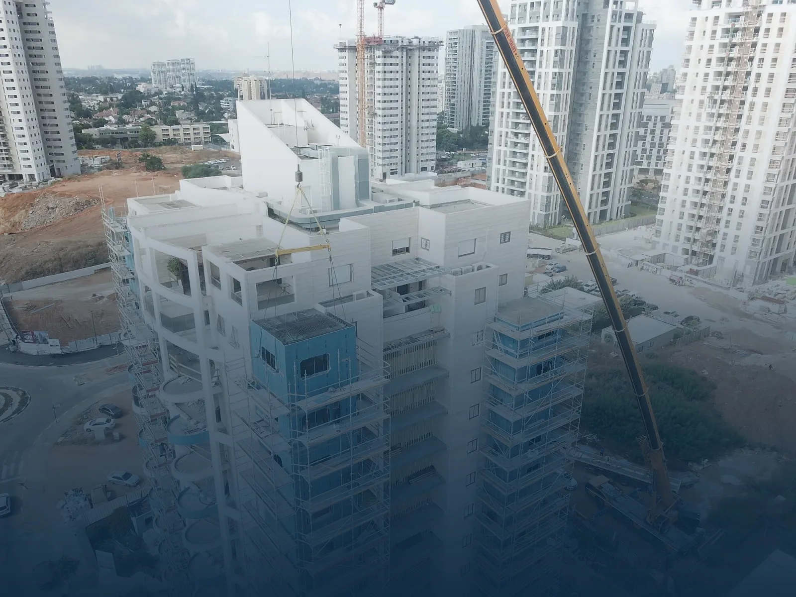 מנוף מרים אלמנט ממ"ד של iForm ומניח אותו במקומו בפרויקט בנייה