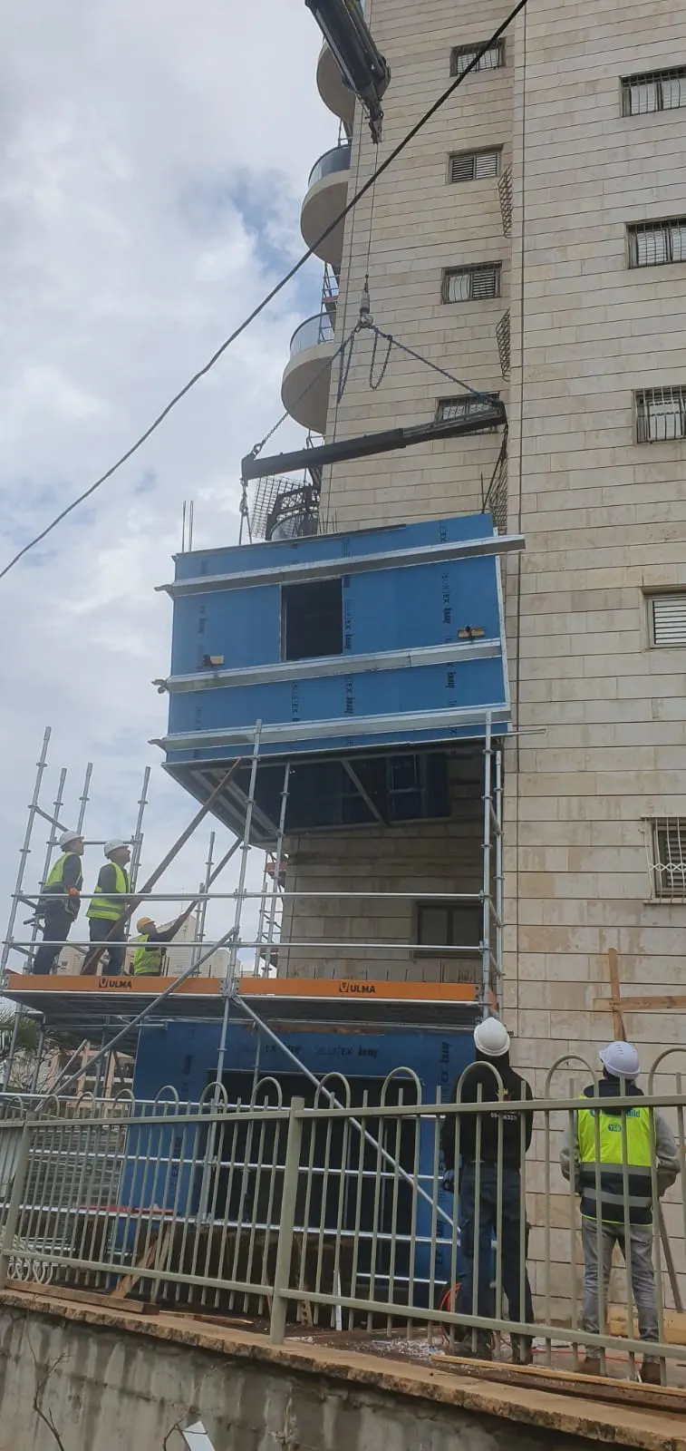 מודול ממ"ד מונף בעזרת מנוף לצד בית מגורים עם גג רעפים אדום